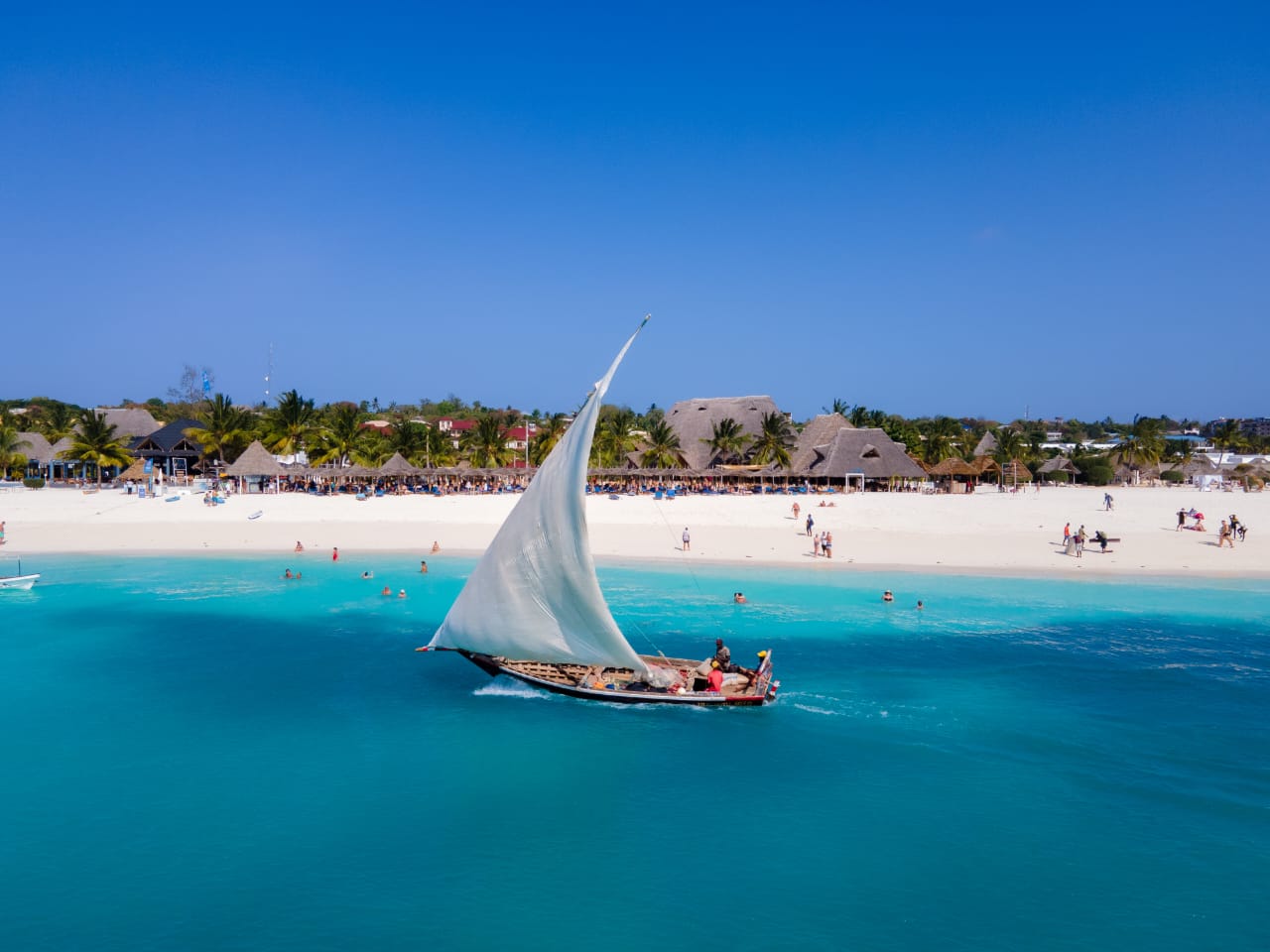 Aerial view of a coastal town with sandy beach and turquoise water
